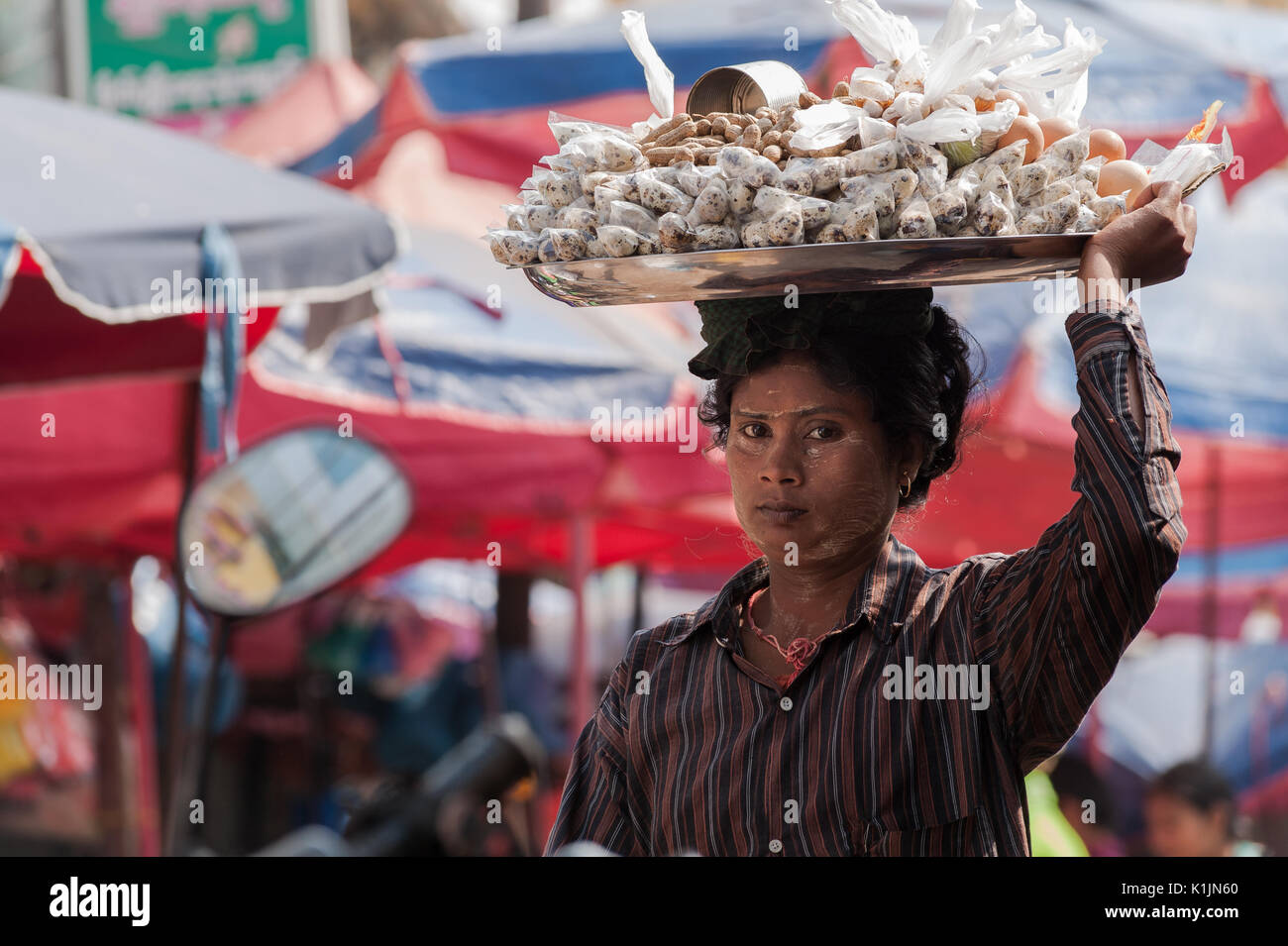 Una donna vende spuntini portati sulla parte superiore della sua testa al Mercato Centrale in Mawlamyine, Stato Mon, Myanmar. Foto Stock