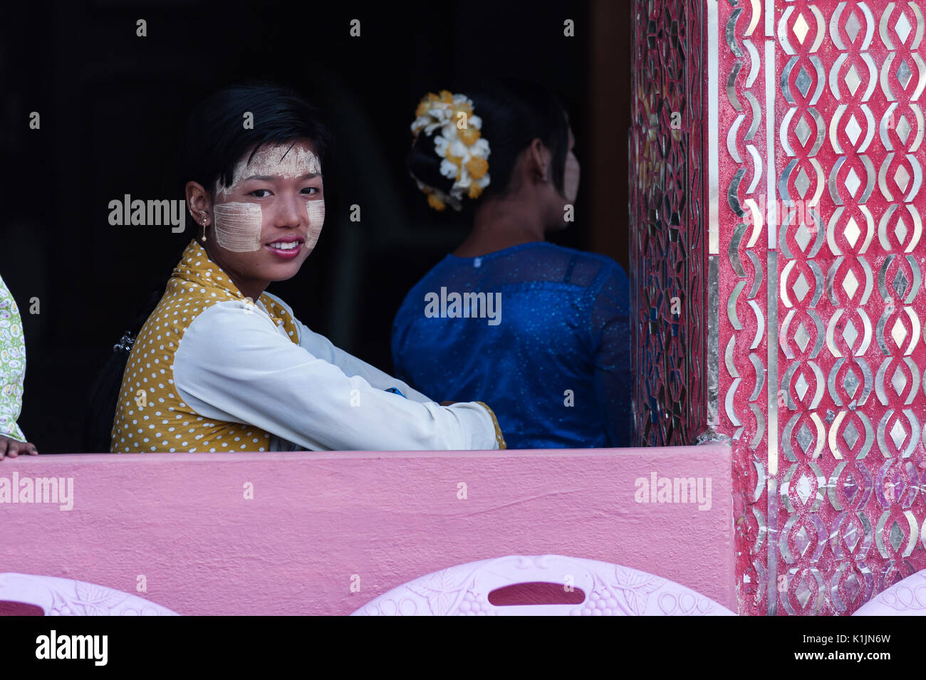Una giovane ragazza con thanaka-faccia dipinta assiste le feste religiose a Taung Min Gyi Pagoda, Amarapura, Myanmar. Foto Stock