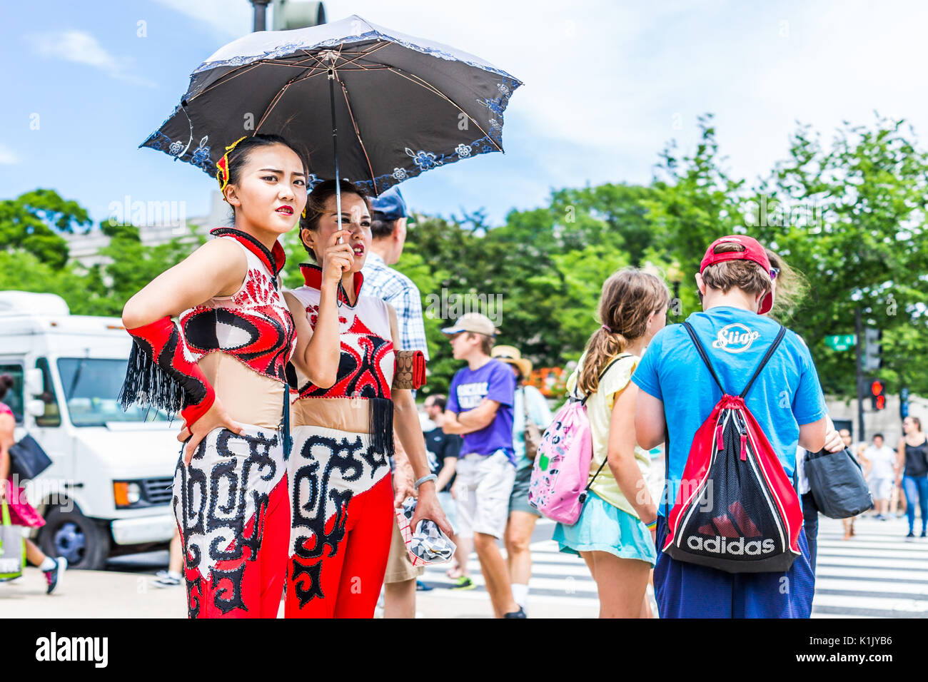 Washington DC, Stati Uniti d'America - 3 Luglio 2017: Turisti in attesa di cross street road sul National Mall con ingrandimento di ragazze cinesi ombrello di contenimento Foto Stock