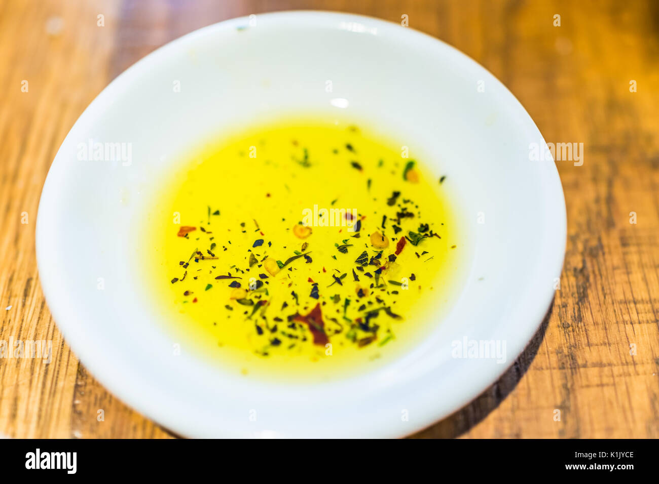 Appartamento vista dall'alto di erborinati olio d'oliva nella piccola piastra bianca Foto Stock