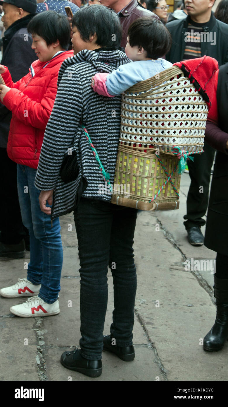 Tessuto baby carrier, scene di strada, Ciqikou Città Vecchia, Chongqing, la Cina. Foto Stock