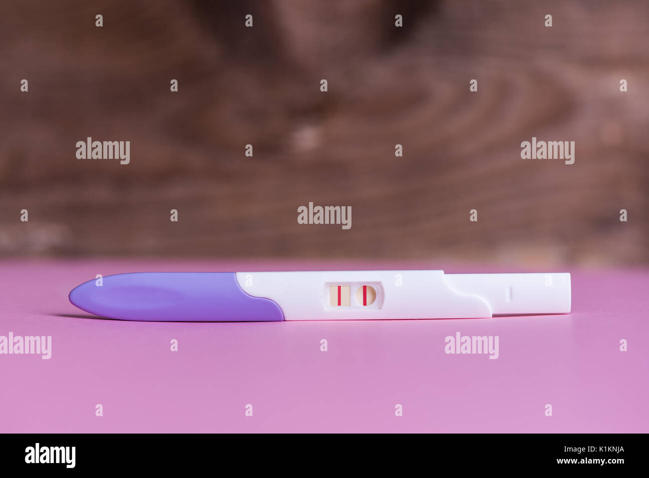 Positivo al test di gravidanza su sfondo rosa Foto stock - Alamy