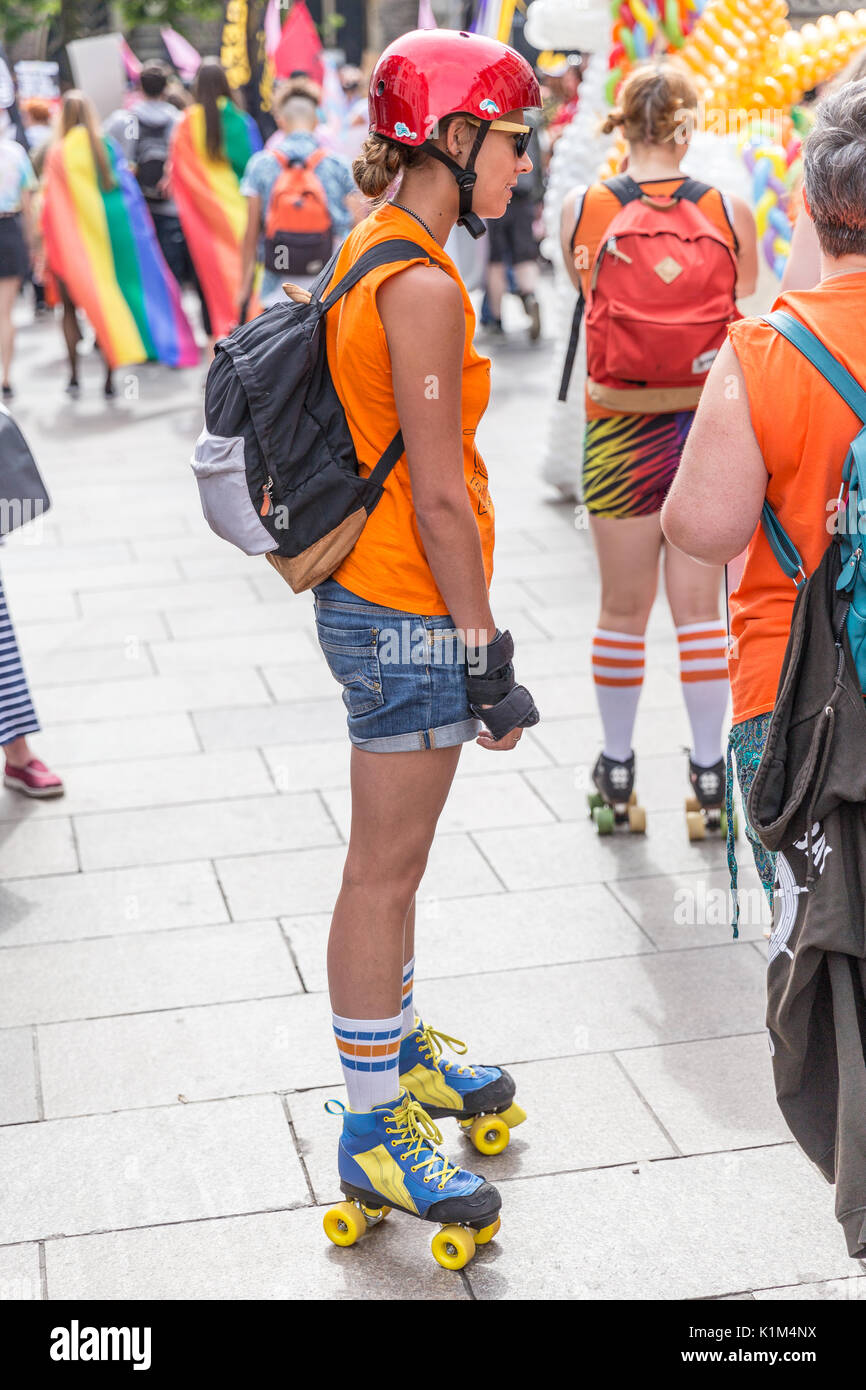 Un girld indossando i pattini a rotelle e casco rosso esegue in Cardiff Pride Parade, 2017 Foto Stock