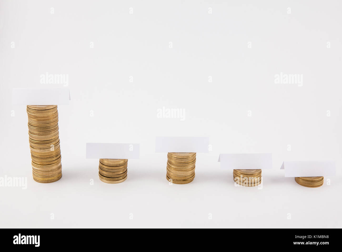 Pile di monete isolato in uno sfondo bianco con etichette vuote Foto Stock
