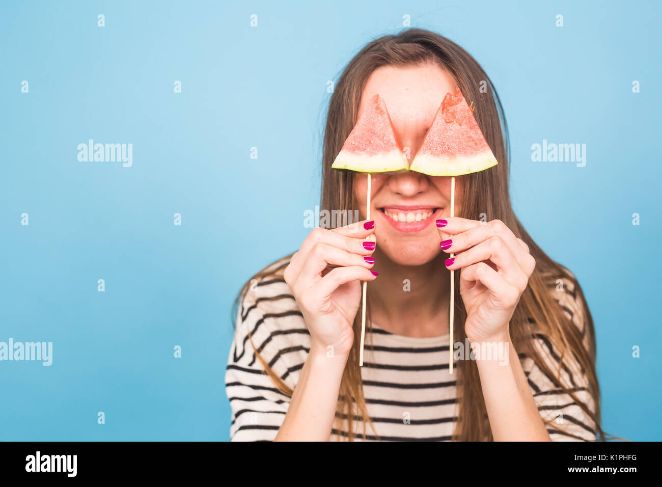 Estate, vacanze, dieta e vegani concetto - Bella sorridente giovane donna holding anguria fetta su stick. Foto Stock