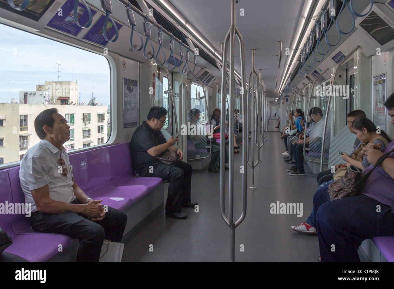 I passeggeri seduti sulla linea viola treno MRT, Bangkok, Thailandia Foto Stock