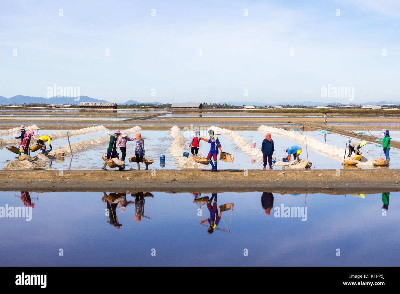 I lavoratori di raccolta sale di mare dalle saline, Petchaburi provincia, Thailandia Foto Stock