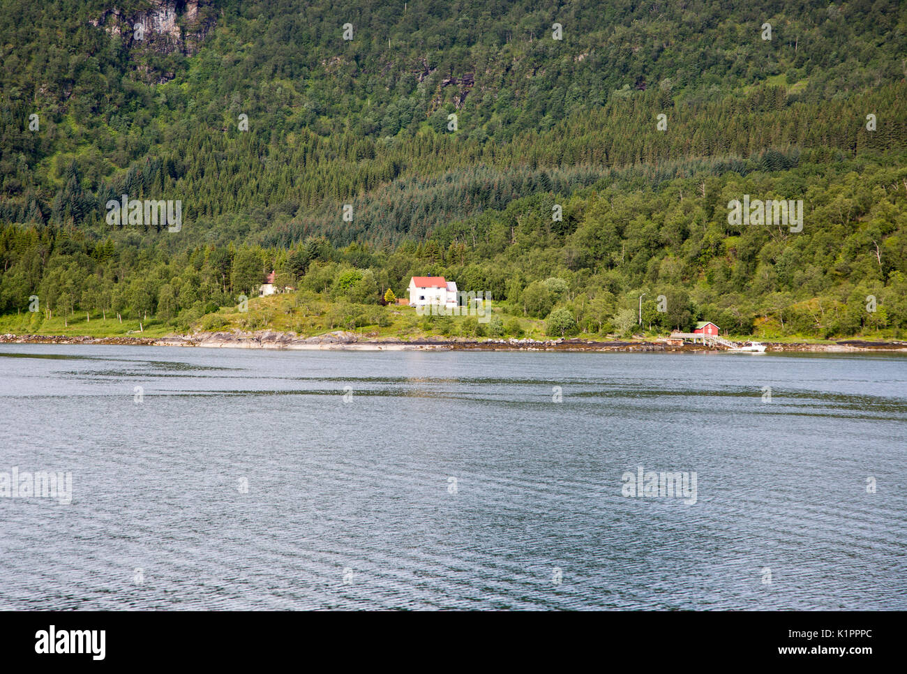 Isolate case costiere sul terreno boscoso nei pressi di Ornes, Nordland, Norvegia Foto Stock