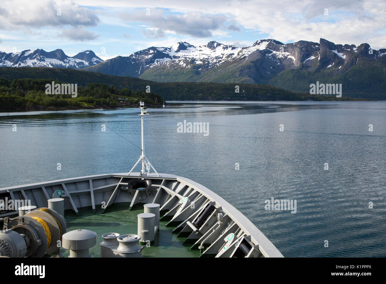 Prua di Hurtigruten nave traghetto nei pressi di Ornes, Nordland, Norvegia Snow capped aspre montagne Foto Stock