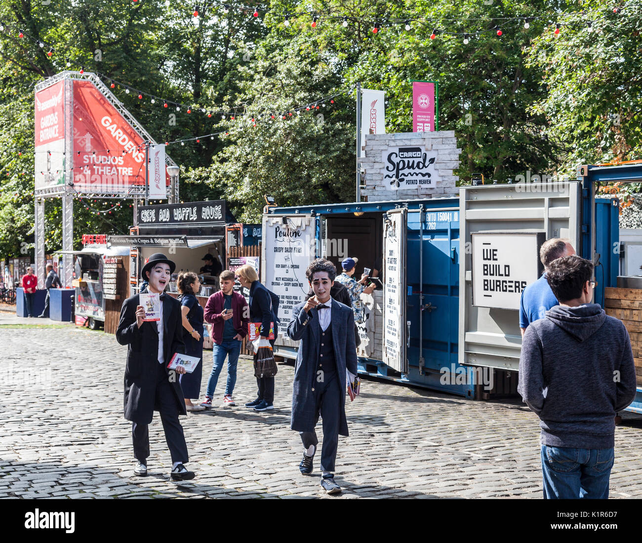 Due artisti dalla Korean magic show Snap volantinaggio a George Square, Edinburgh Fringe. Sullo sfondo di un pop-up fast food, fringe- Foto Stock