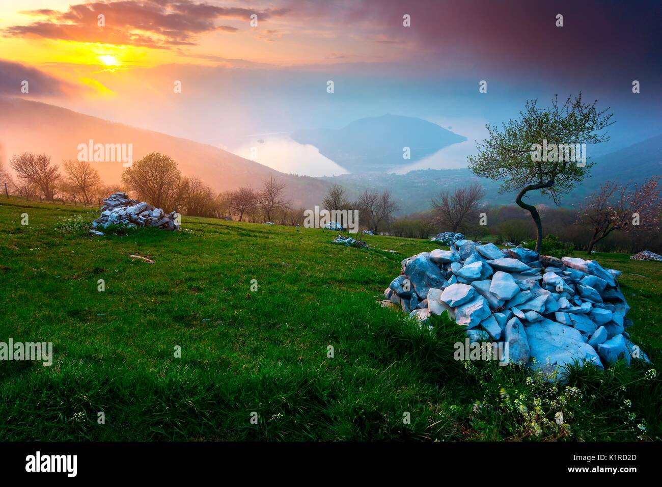 Il lago d'Iseo, al tramonto. L'isola di Monte Isola nel mezzo del lago, chiuso nelle montagne che dividono le due province di Bergamo e Brescia Foto Stock