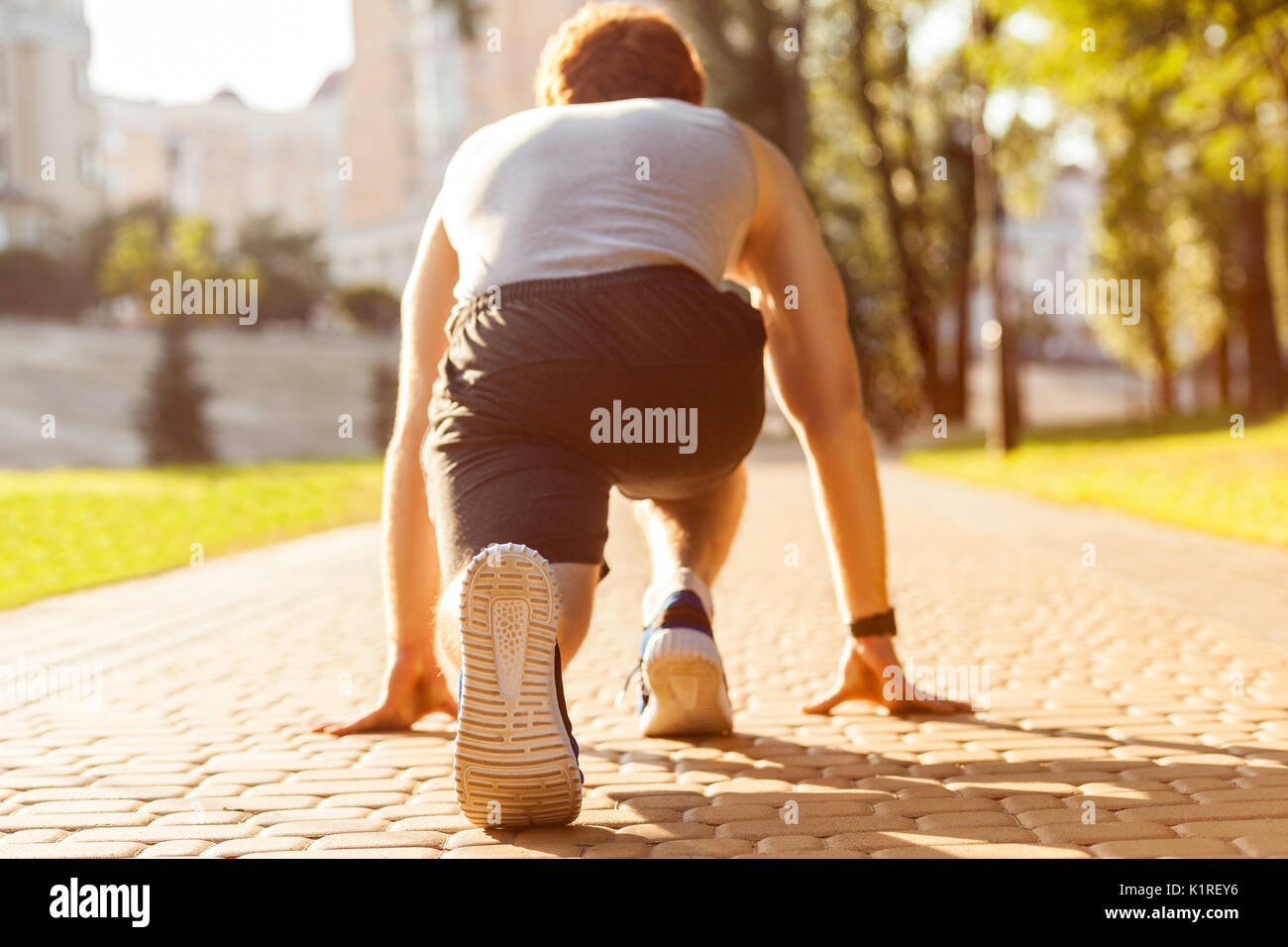 Atletica Giovane uomo jogging al mattino. Bassa star. Modello di fitness in esercizio crossfit all'esterno. Uno stile di vita sano concetto. Foto Stock
