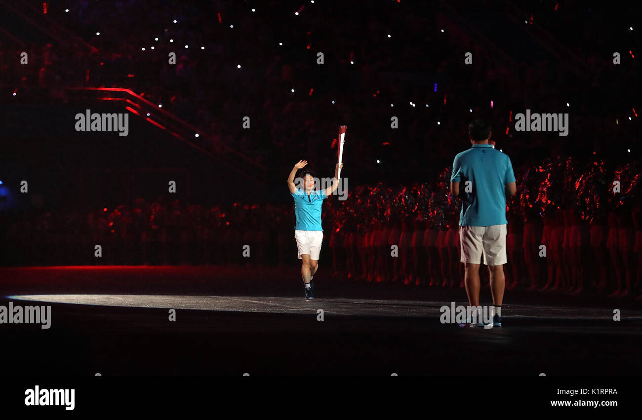 Tianjin. Il 27 agosto, 2017. Torchbearer Xie Pingping corre con la torcia durante la cerimonia di apertura del XIII cinese Giochi Nazionali nel nord della Cina di Tianjin comune, e il agosto 27, 2017. Credito: Cao può/Xinhua/Alamy Live News Foto Stock