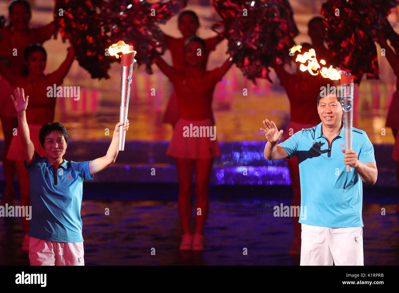 Tianjin. Il 27 agosto, 2017. Torchbearers Xie Pingping (L) e Wang Baoquan prendere parte al relè della torcia durante la cerimonia di apertura del XIII cinese Giochi Nazionali nel nord della Cina di Tianjin comune, e il agosto 27, 2017. Credito: Maohua Fei/Xinhua/Alamy Live News Foto Stock