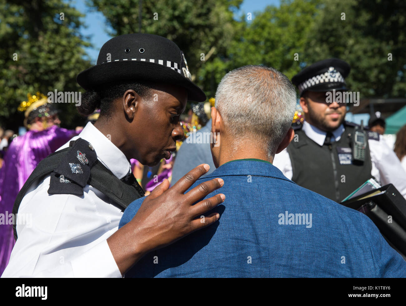 Una poliziotta ha una parola con il sindaco di Londra, Sadiq Khan, al carnevale di Notting Hill 2017.Ha parlato del Grenfell fire tragedia Foto Stock