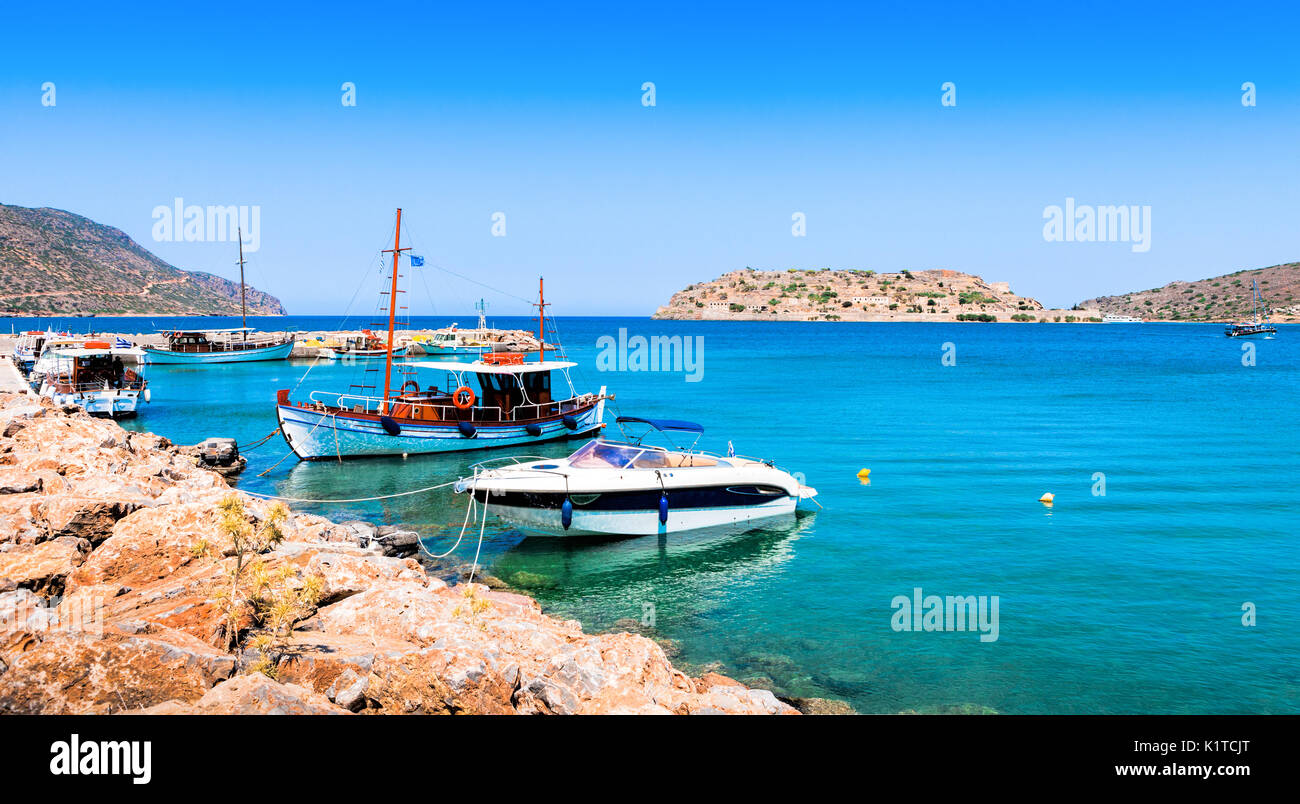Turistiche e barche da pesca al molo del villaggio di Plaka, vicino all'isola di Spinalonga. Creta, Grecia. Foto Stock