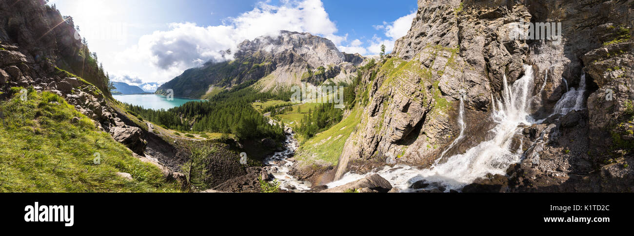 Vista panoramica di un torrent stream sorgente e del lago in una verde vallata nelle Alpi Svizzere montagne nella soleggiata estate, perfetto per banner Foto Stock