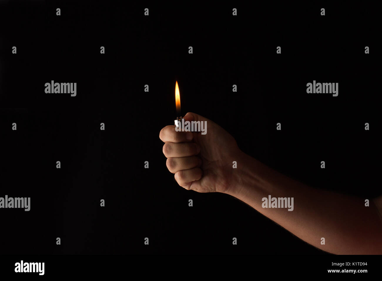 Mano che tiene un accendino in un oscuro Foto stock - Alamy