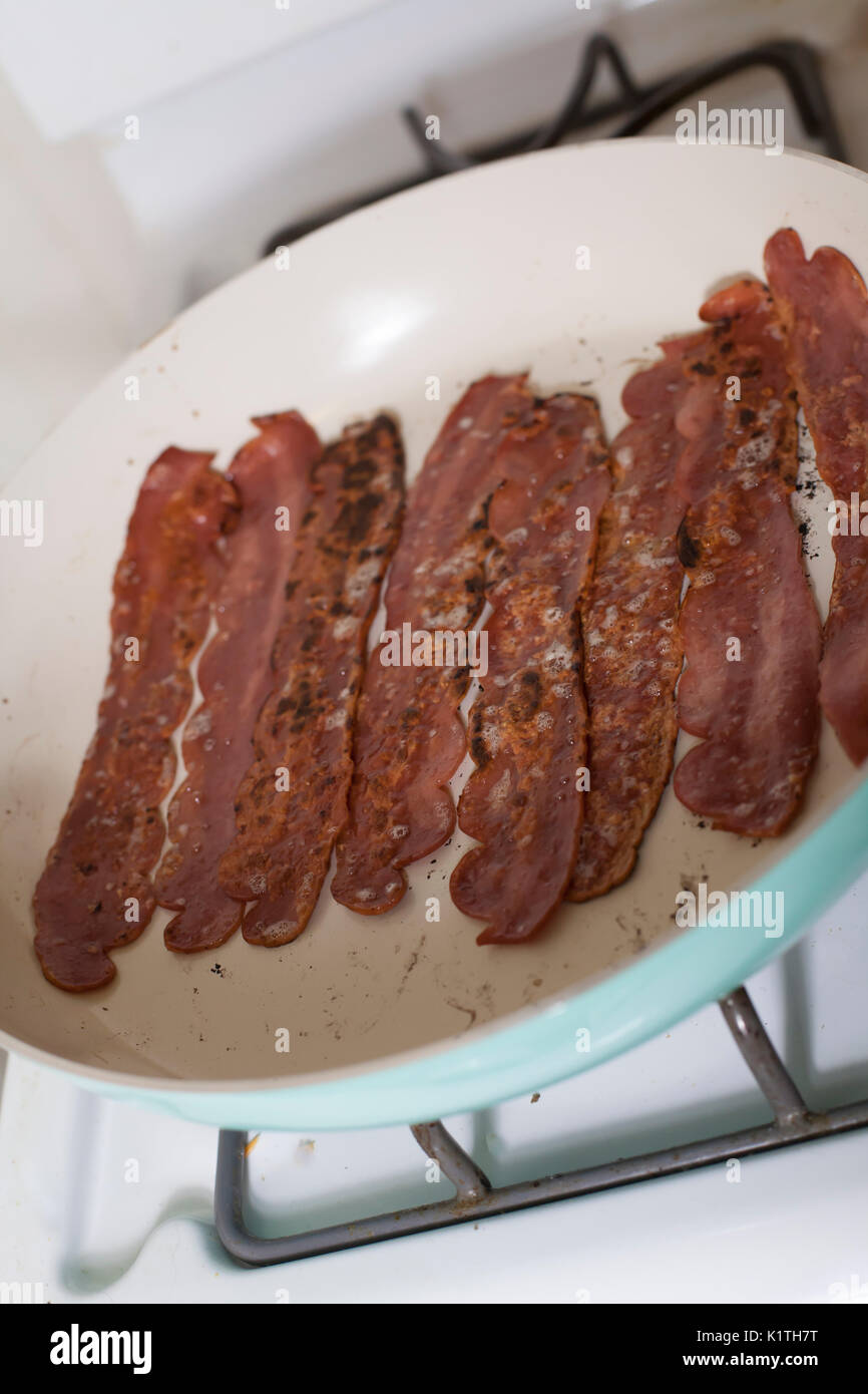 Close up di bacon friggere in una padella Foto Stock