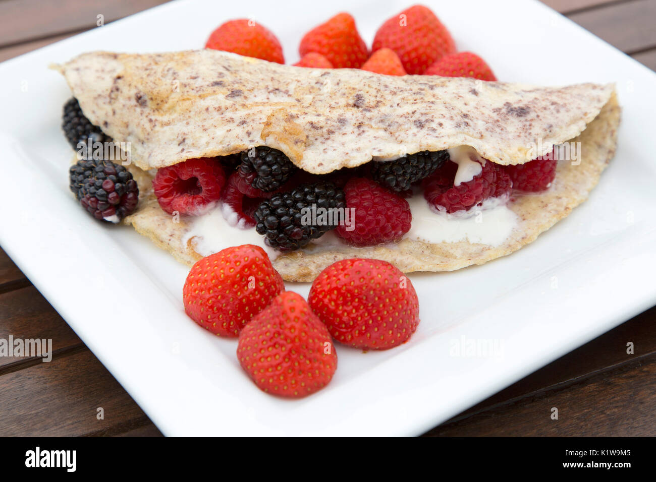 Una frittata di Berry è servito per la prima colazione. Le funzioni di frittata di cannella e viene rabboccato con yogurt greco e fragole, lamponi e more. Foto Stock