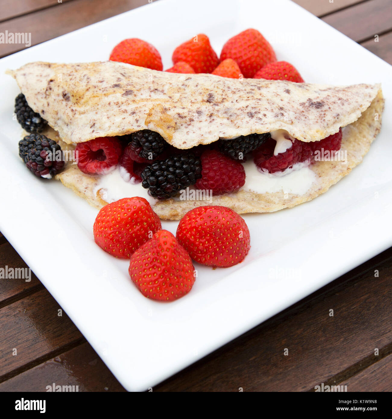 Una frittata di Berry è servito per la prima colazione. Le funzioni di frittata di cannella e viene rabboccato con yogurt greco e fragole, lamponi e more. Foto Stock