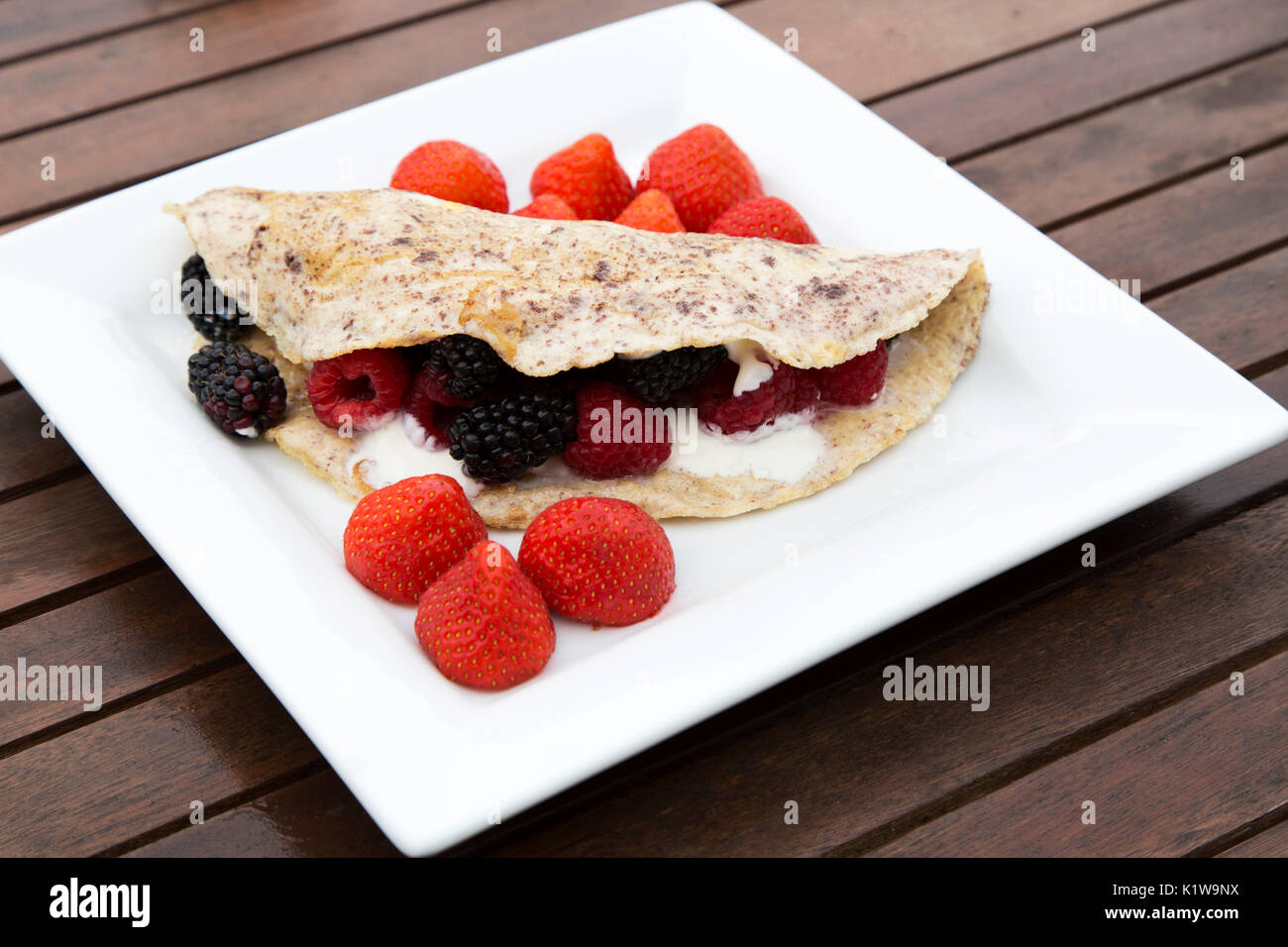 Una frittata di Berry è servito per la prima colazione. Le funzioni di frittata di cannella e viene rabboccato con yogurt greco e fragole, lamponi e more. Foto Stock