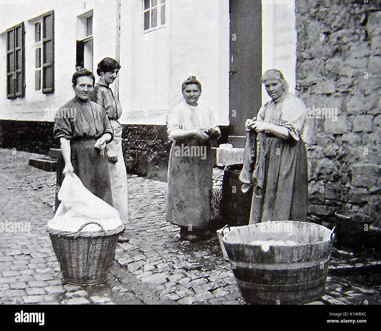 1940 - un gruppo di lavandaie belga o casalinghe con i loro cestini e vasche di lavaggio in Bouvignes-sur-Meus Foto Stock