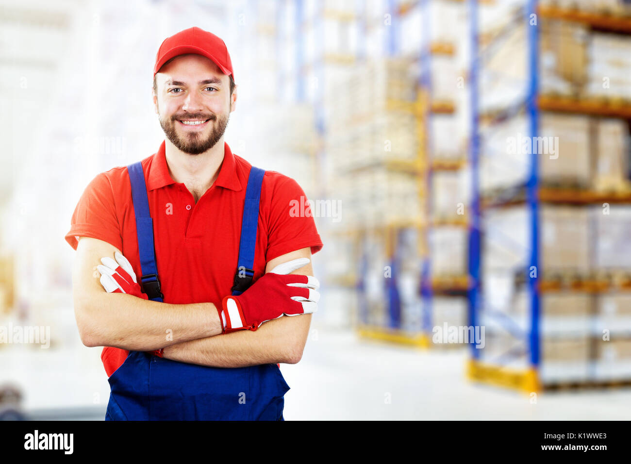 Sorridente giovane operaio di magazzino in rosso uniforme. spazio copia Foto Stock