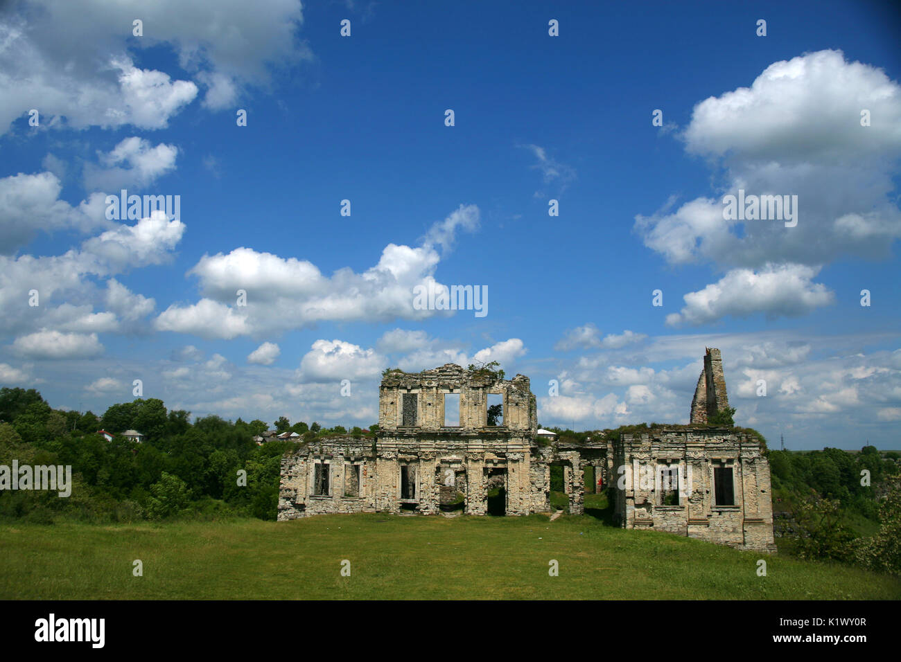 Cancella giorno nuvole bianche di un edificio abbandonato di pietra si erge nel mezzo di una valle di steppa Foto Stock