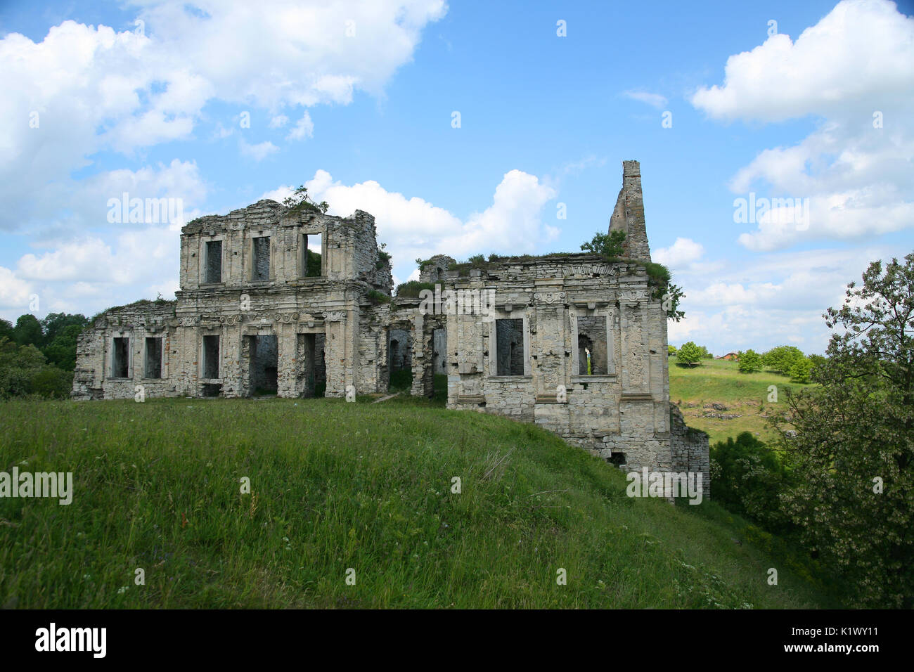 Cancella giorno nuvole bianche di un edificio abbandonato di pietra si erge nel mezzo di una valle di steppa Foto Stock