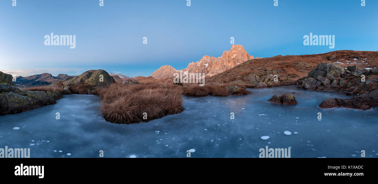 L'Europa, Italia, Trentino Alto Adige. Icy piccolo stagno sulla Cavallazza Piccola gruppo del Lagorai. Sullo sfondo il Monte Mulaz e Cimon della Pala Foto Stock