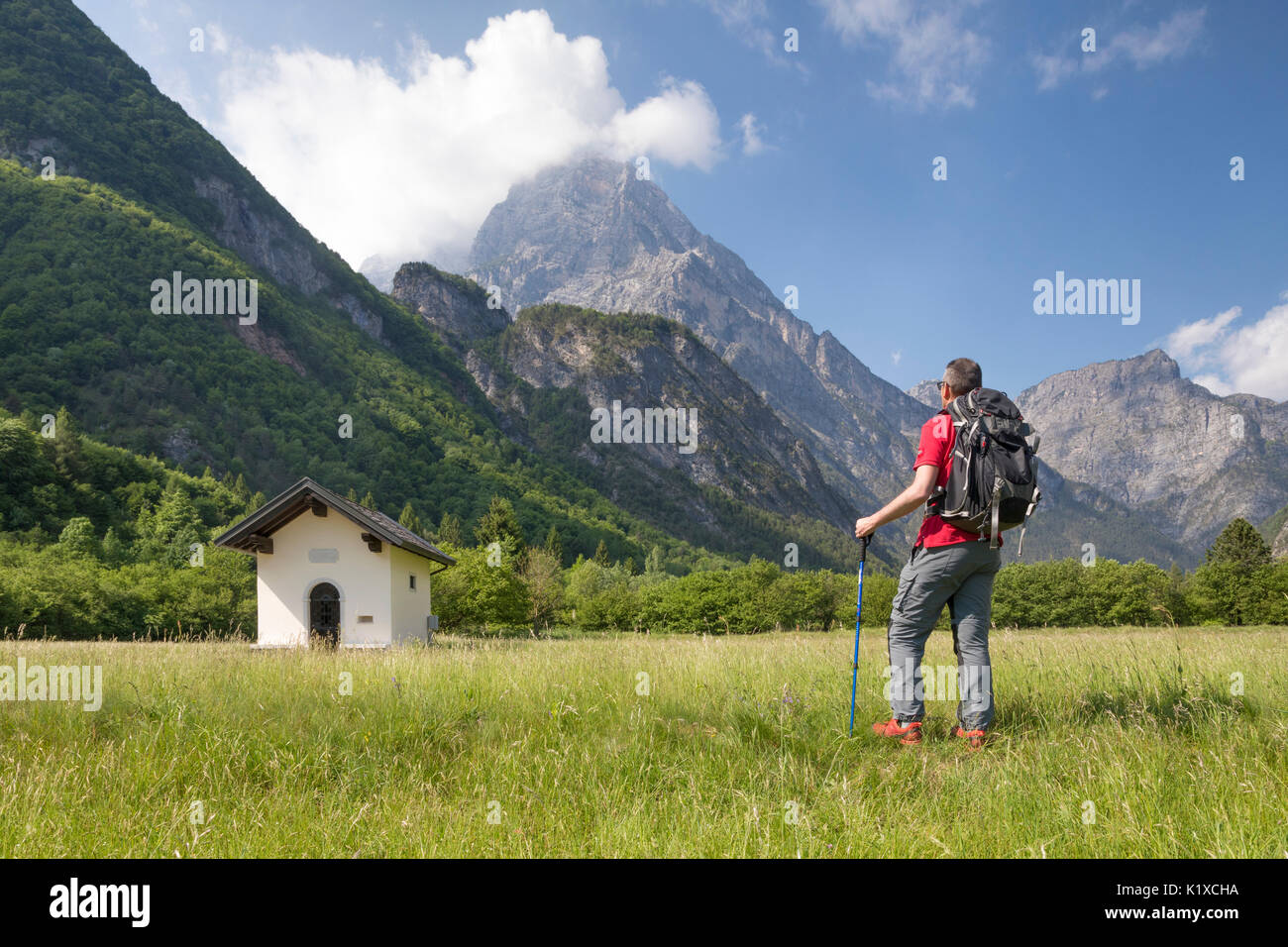 Escursionista nei pressi di una piccola chiesa lungo la Val Cimoliana road, Cimolais, Pordenone, Friuli Venezia Giulia, Italia, Europa Foto Stock