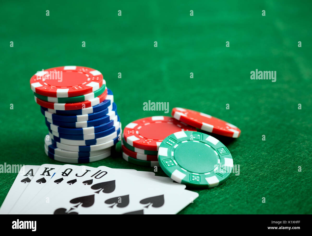 Casino tavolo verde con patatine e royal flush di carte da gioco. Gioco del poker concetto Foto Stock