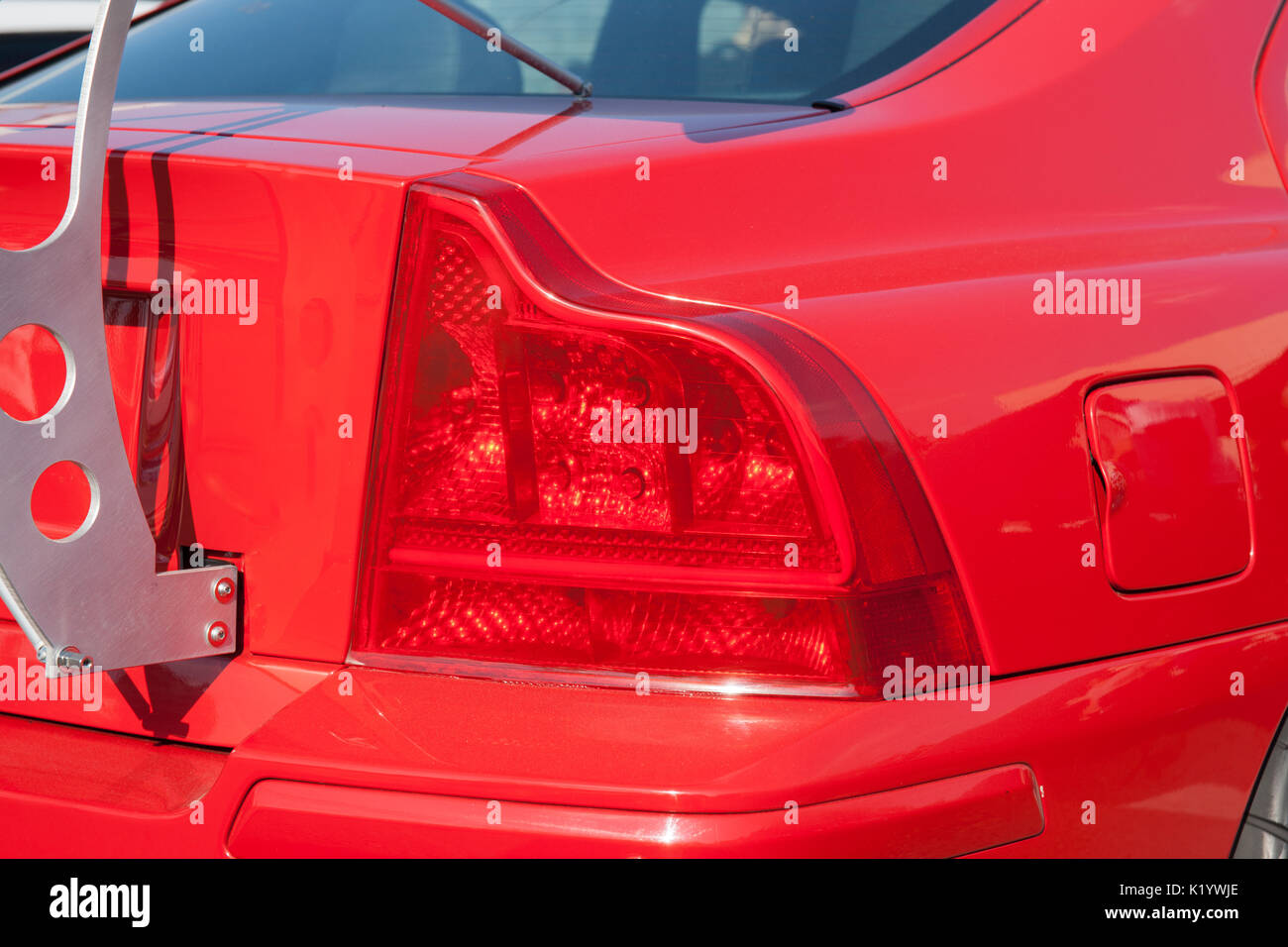 Luci rosse posteriori di un automobile sportiva rossa. Metallo bianco il sostegno di un spoiler posteriore. Bella la tecnologia automobilistica. Design elegante. Foto Stock