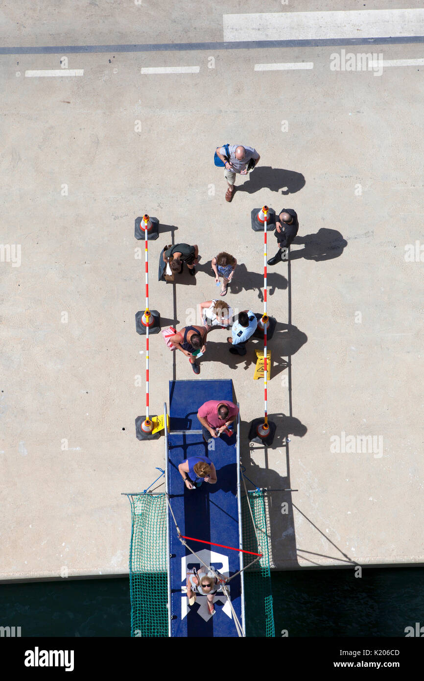 I vacanzieri di ritornare alla loro nave da crociera camminando sulla passerella di collegamento Foto Stock
