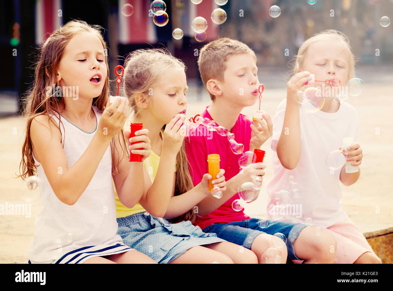 I bambini cercando di catturare le bolle di sapone in giardino Foto stock -  Alamy