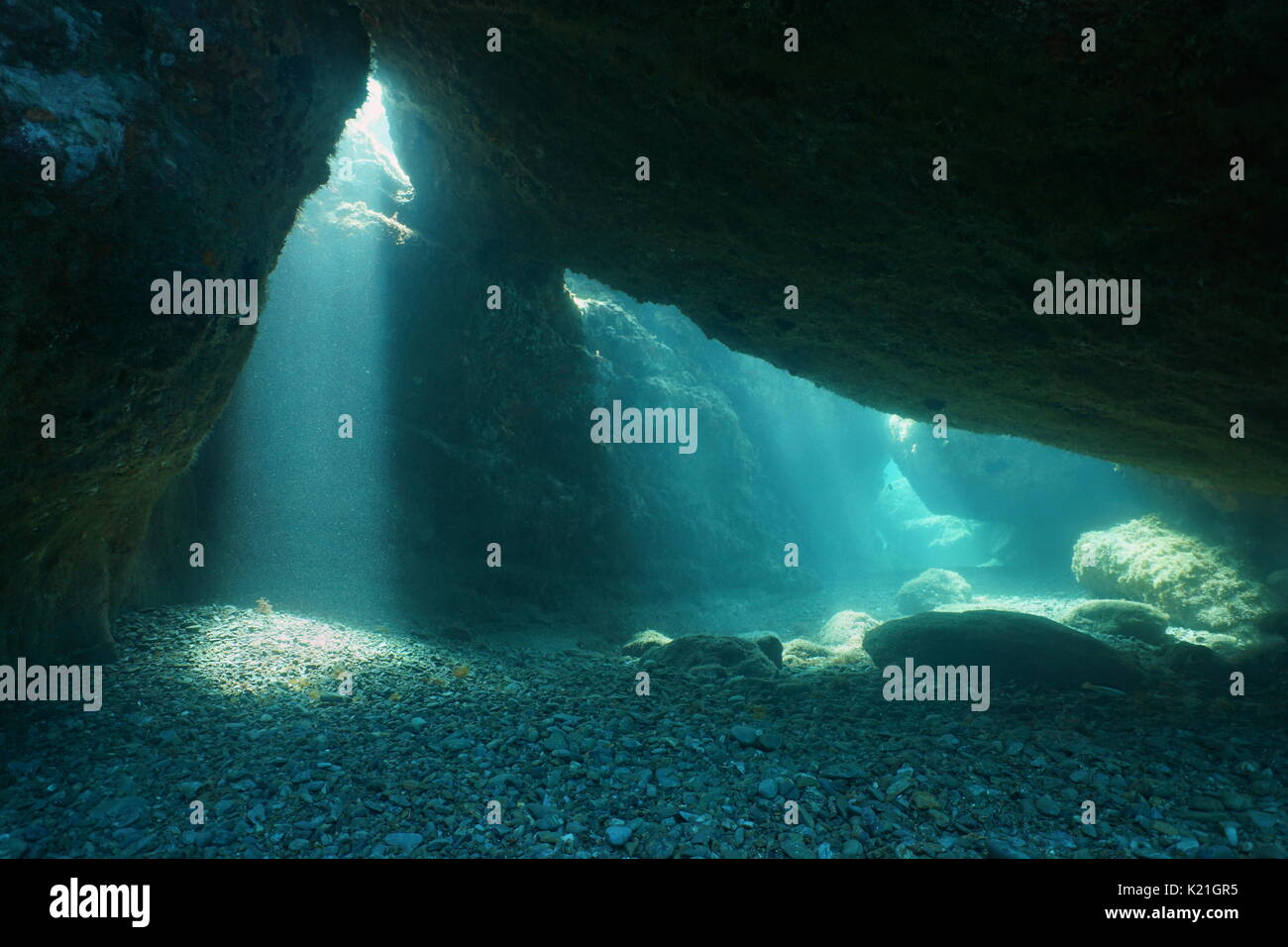 Al di sotto di grandi rocce subacquei con sunbeam dal foro, mare Mediterraneo, scenario naturale, Pirenei orientali, Roussillon, Francia Foto Stock