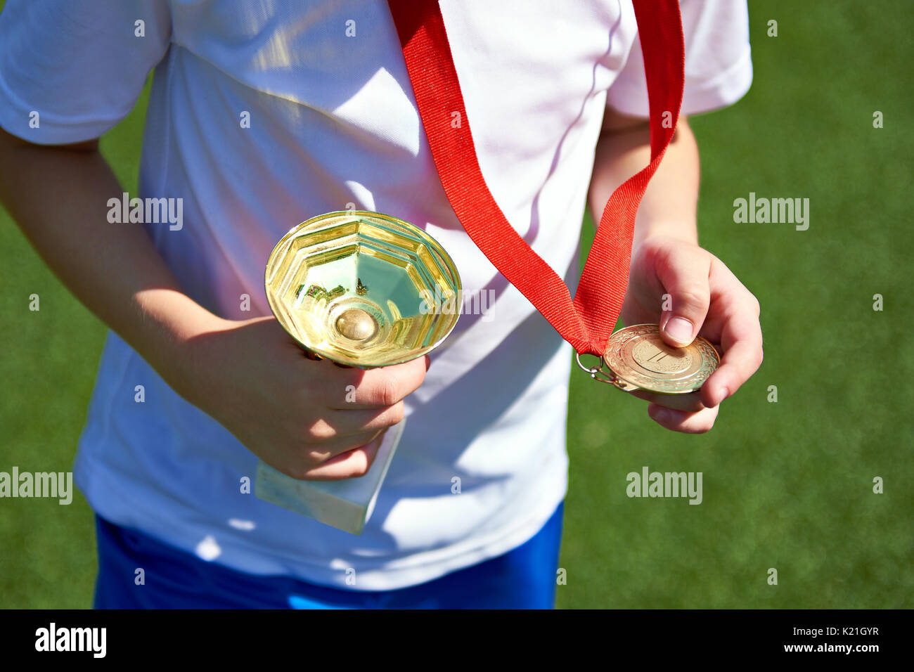 Vincitore boy sportivo con coppa e medaglia d'oro Foto Stock