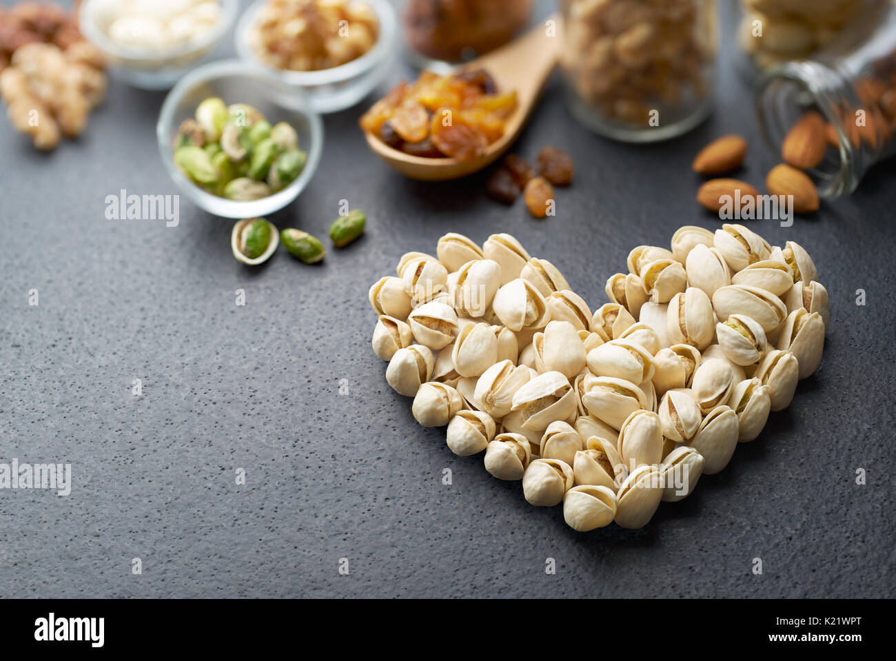 I pistacchi formando un cuore-forma su sfondo di ardesia Foto Stock