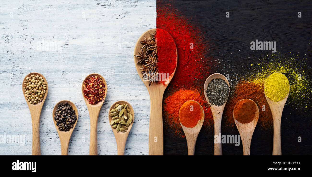 Cucchiaio di legno riempita con spezie, erbe, polveri e le spezie in polvere Foto Stock