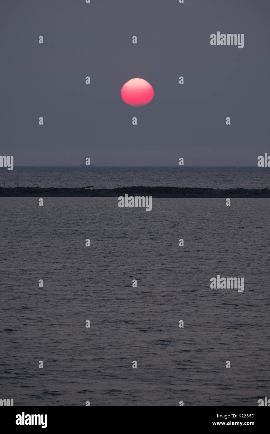 Impostazione sole visto attraverso la foresta incendio fumo di Puget Sound, guardacoste, Washington, Stati Uniti d'America Foto Stock