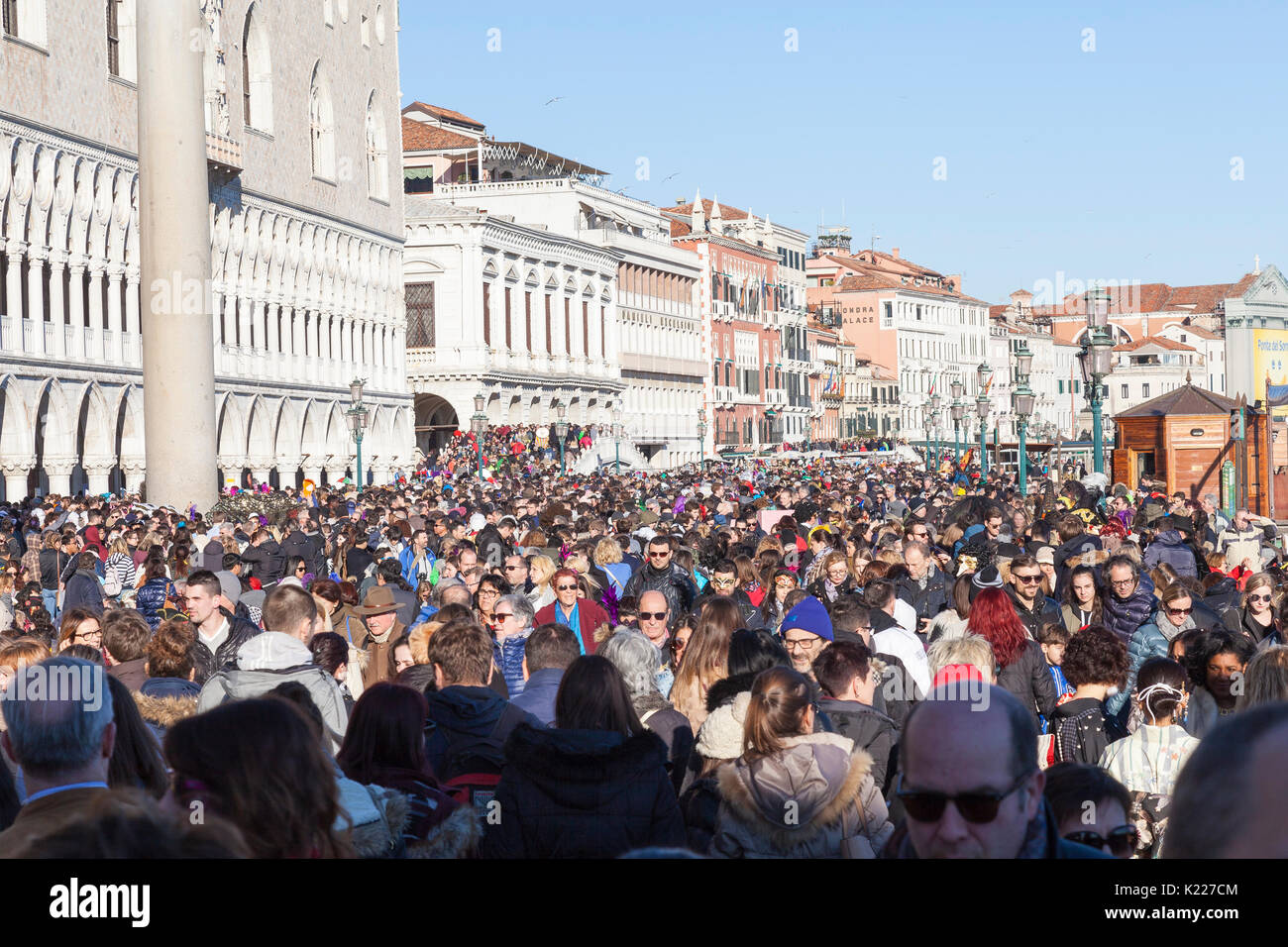 La folla di turisti durante il Carnevale 2017 a Venezia, Italia di fronte al Palazzo dei Dogi pranzo solido in Piazza San Marco che risale lungo la waterf Foto Stock
