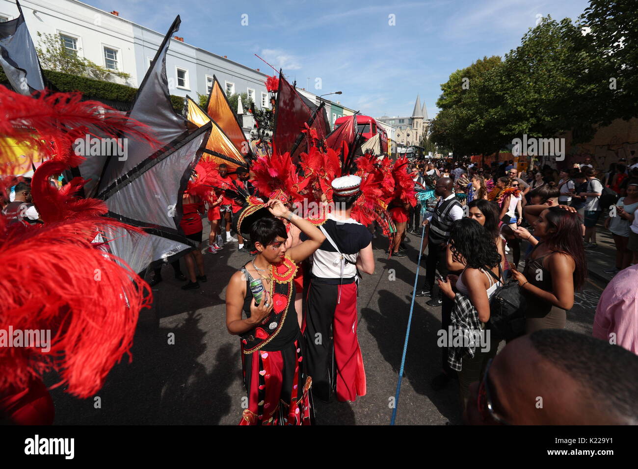 Gli artisti interpreti o esecutori dal Sunshine International Arts di osservare un minuto di silenzio in memoria delle vittime della torre Grenfell fuoco durante il secondo e ultimo giorno del carnevale di Notting Hill a ovest di Londra. Foto Stock