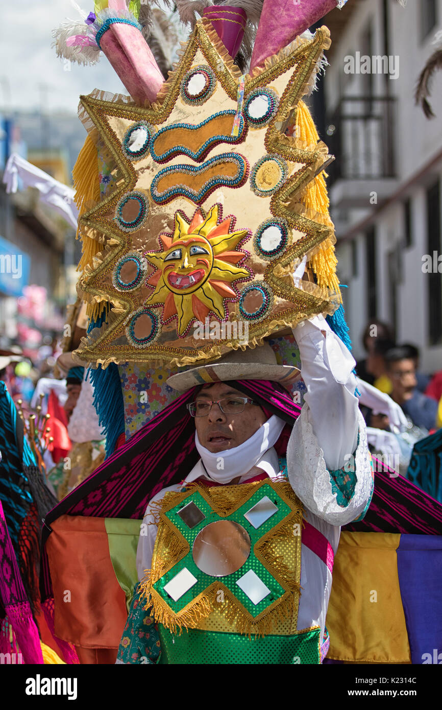 Giugno 17, 2017 Pujili, Ecuador: uomo indigeni di bilanciamento di acconciatura di grandi dimensioni durante la festa del Corpus Christi danze di strada Foto Stock