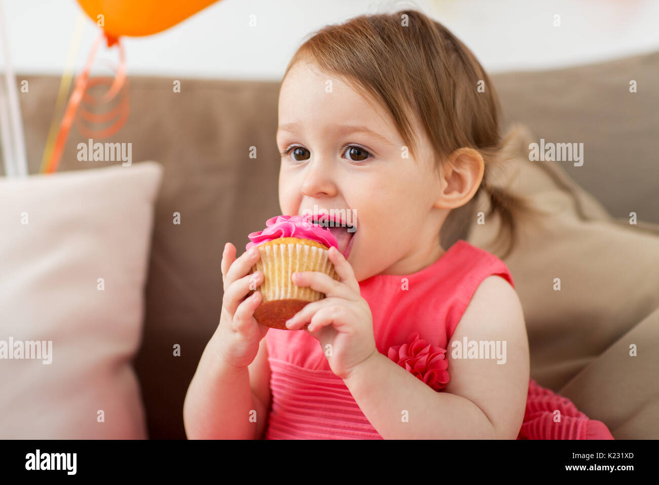 Happy Baby girl mangiare cupcake sulla festa di compleanno Foto Stock