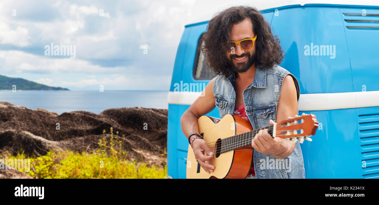 Hippie uomo a suonare la chitarra in minivan auto sull'isola Foto Stock