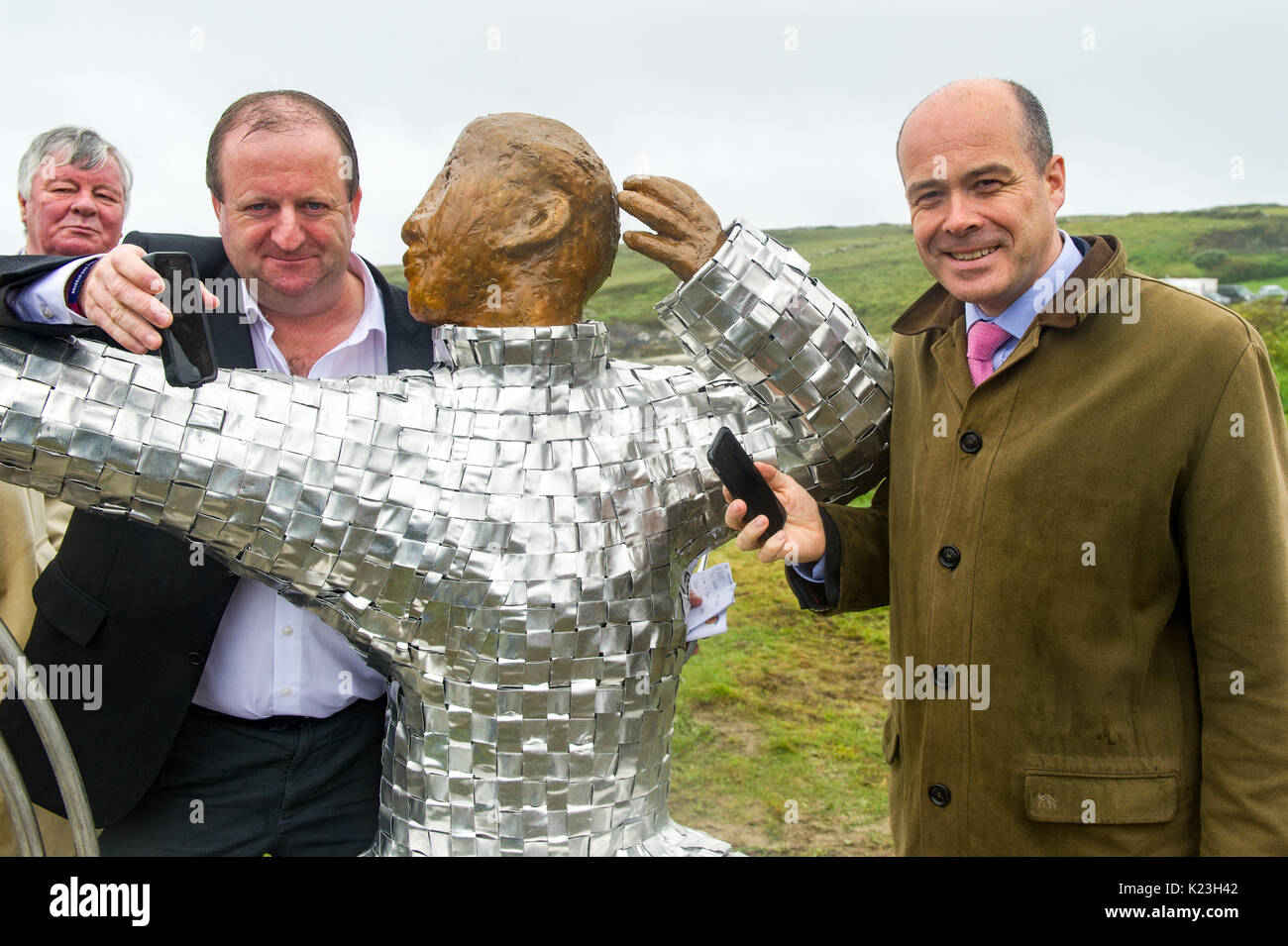 Galley Cove, Irlanda. 28 Agosto 2017. Comunicazioni il Ministro Denis Naughten e il Vice Michael Collins TD con Cllr. Joe Carroll guardando sopra, mostra come le comunicazioni sono progredite sull'ocassione della scoperta di una statua di Guglielmo Marconi che ha aperto la strada alle comunicazioni radio a lunga distanza. Credit: Notizie dal vivo di AG/Alamy. Foto Stock