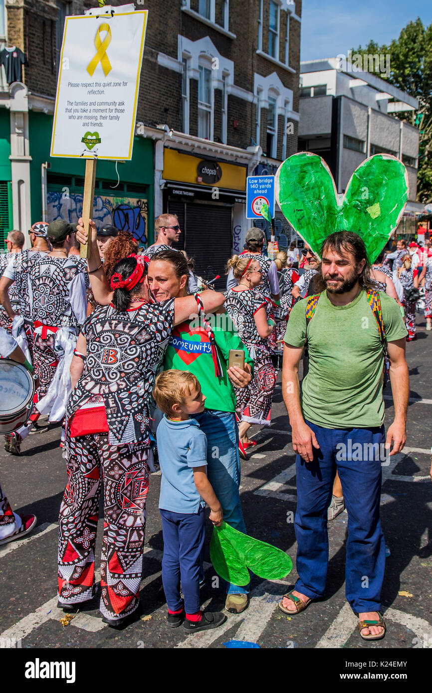 Londra, Regno Unito. 28 Agosto, 2017. Membri del tamburo di Batala band dal Brasile smettere di giocare e abbraccio i residenti che chiedere agisce per onorare una zona tranquilla per ricordare la torre Grenfell tragedia - il lunedì del carnevale di Notting Hill. La manifestazione annuale sulle strade del Royal Borough di Kensington e Chelsea, oltre a ferragosto weekend. Esso è guidato dai membri della British West comunità indiana, e attira circa un milione di persone ogni anno, il che lo rende uno dei più grandi del mondo street festival. Credito: Guy Bell/Alamy Live News Foto Stock