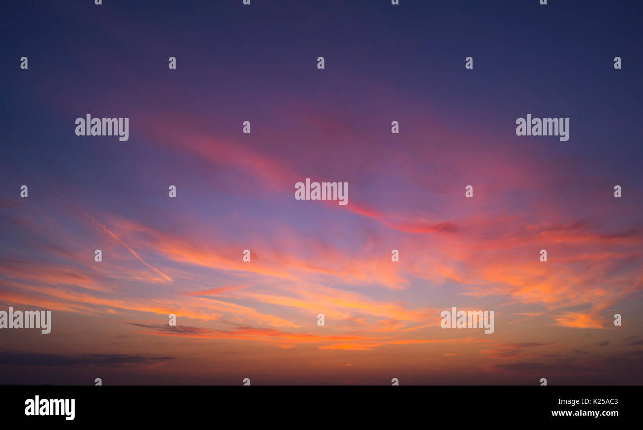 un tramonto arancione con un sole luminoso sul fondo della foto con lo spazio per la copia in alto nuvole grigio blu Foto Stock