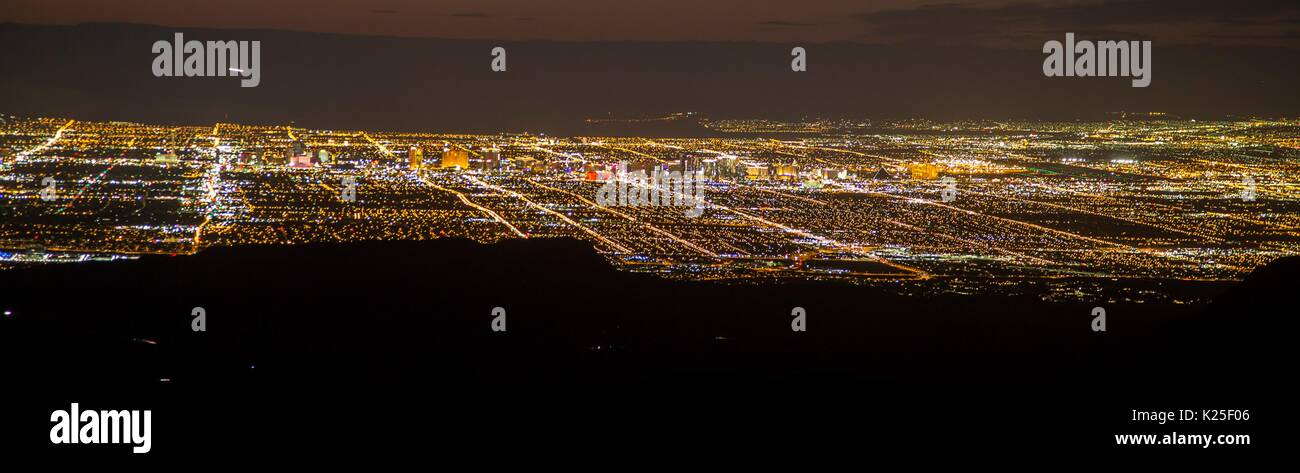 Le luci della città si può vedere di notte da sopra le formazioni rocciose presso il Red Rock Canyon National Conservation Area 27 Settembre 2016 vicino a Las Vegas, Nevada. Foto Stock